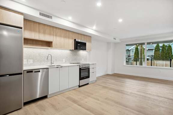 A modern kitchen with stainless steel appliances and wooden cabinets.