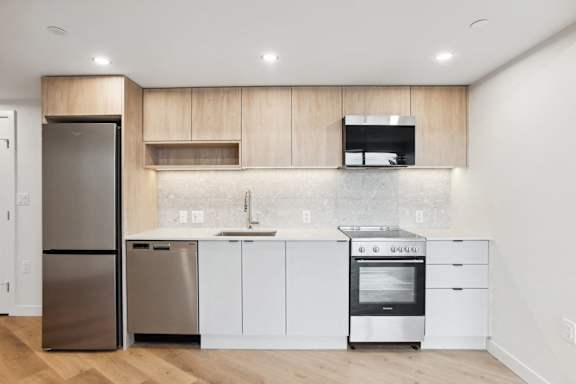A modern kitchen with a stainless steel refrigerator and dishwasher.