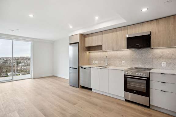 A modern kitchen with wooden cabinets and stainless steel appliances.