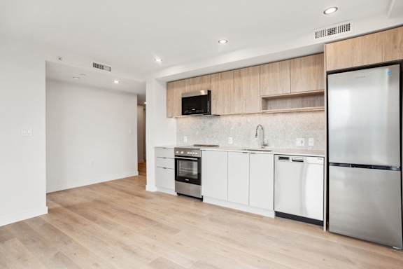 A modern kitchen with wooden cabinets and stainless steel appliances.