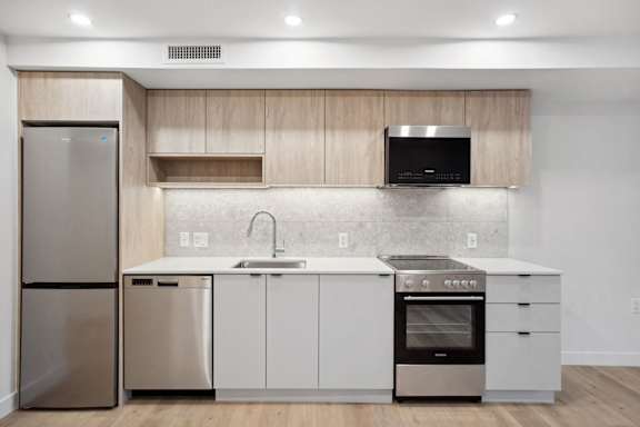 A modern kitchen with stainless steel appliances and white cabinets.