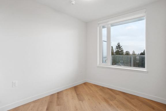 A room with a window and wooden flooring.