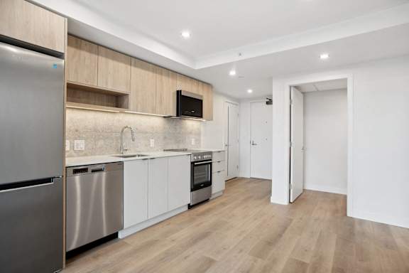 A modern kitchen with wooden cabinets and stainless steel appliances.