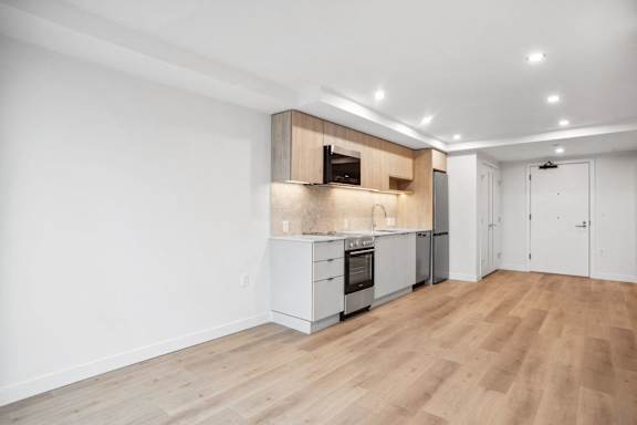 A kitchen with white cabinets and a wooden island.