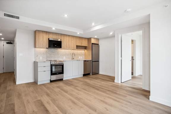 A modern kitchen with wooden floors and white walls.