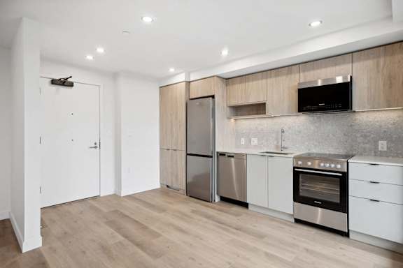 A modern kitchen with stainless steel appliances and wooden cabinets.