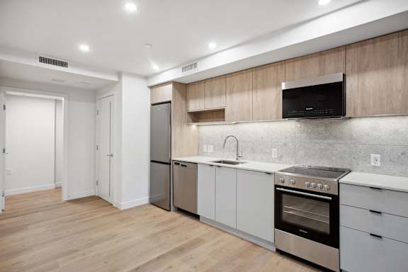 A modern kitchen with wooden cabinets and stainless steel appliances.