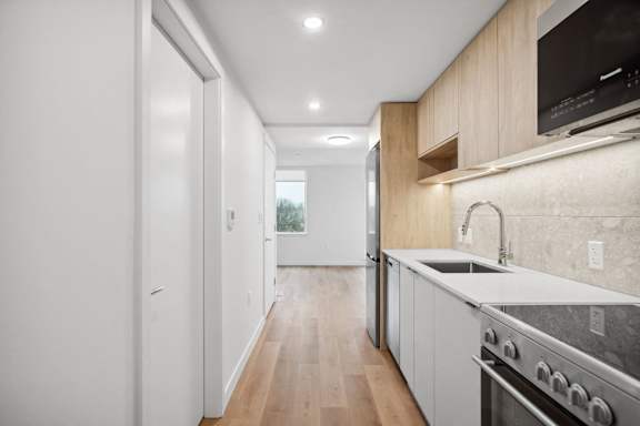 A modern kitchen with a stainless steel oven and wooden cabinets.