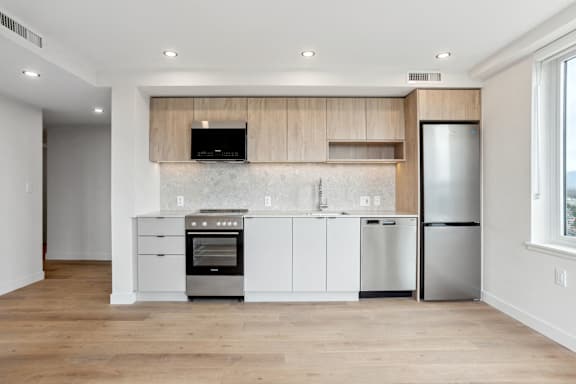 A modern kitchen with a stainless steel refrigerator and oven.