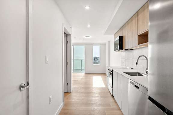 A modern kitchen with white appliances and wooden cabinets.