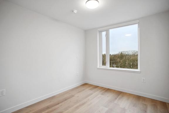 A room with a window and wooden floors.