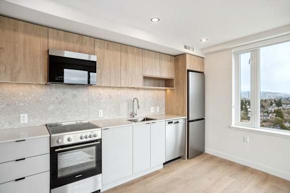 A modern kitchen with white appliances and wooden cabinets.