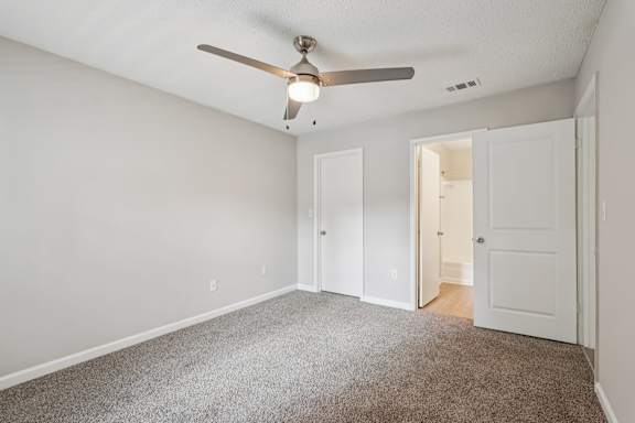 A room with a ceiling fan and carpeted floor.