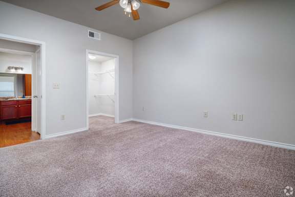 A room with a ceiling fan and carpeted floor.
