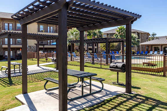 A wooden pergola with a table underneath it.