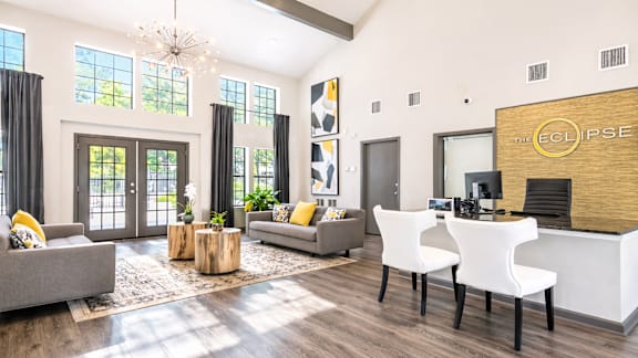 A modern living room with a grey sofa, a white chair, and a wooden coffee table.