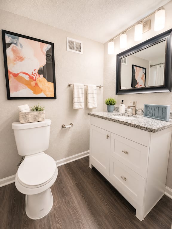 A white toilet sits next to a white sink in a bathroom.