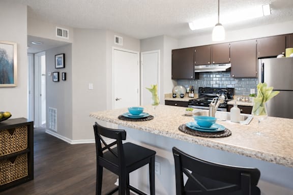 A kitchen with a table and chairs.