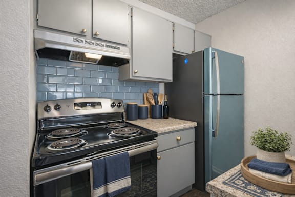 A kitchen with a stove, oven, and refrigerator.