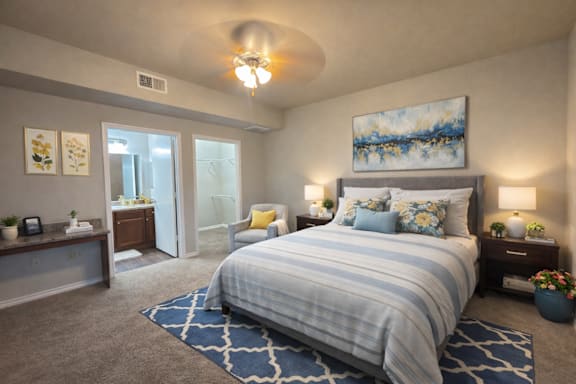 A bedroom with a large bed and a painting on the wall.