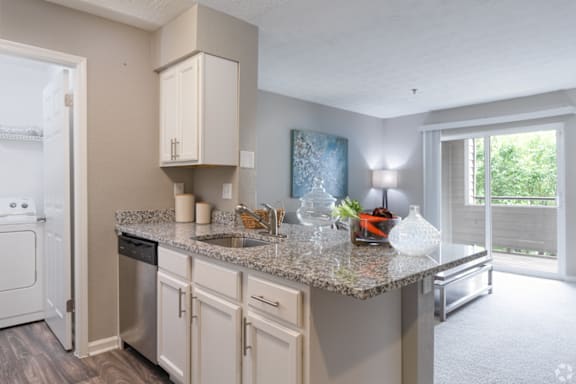 A kitchen with granite countertops and white cabinets.