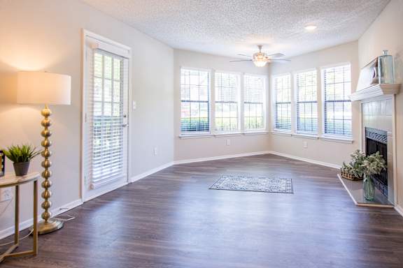A spacious room with a fireplace and a rug on the floor.