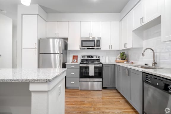 A modern kitchen with stainless steel appliances and white cabinets.