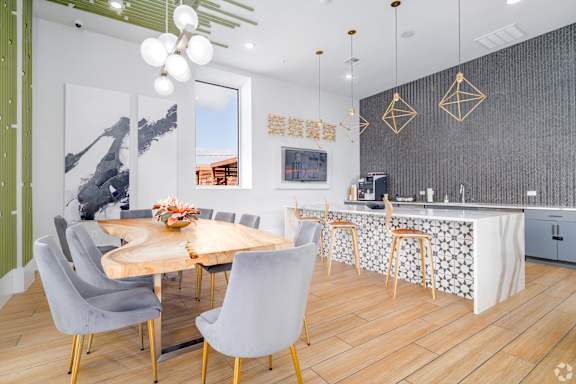 A modern dining room with a wooden table and grey chairs.