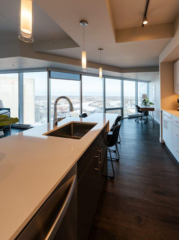 A modern kitchen with a large window overlooking the city.