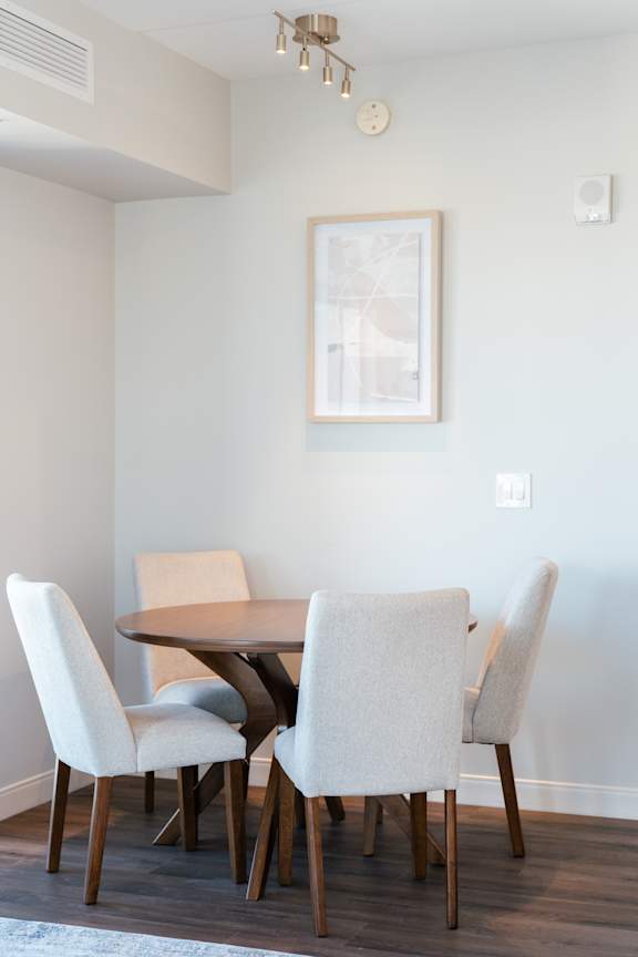 A dining room with a table and chairs.