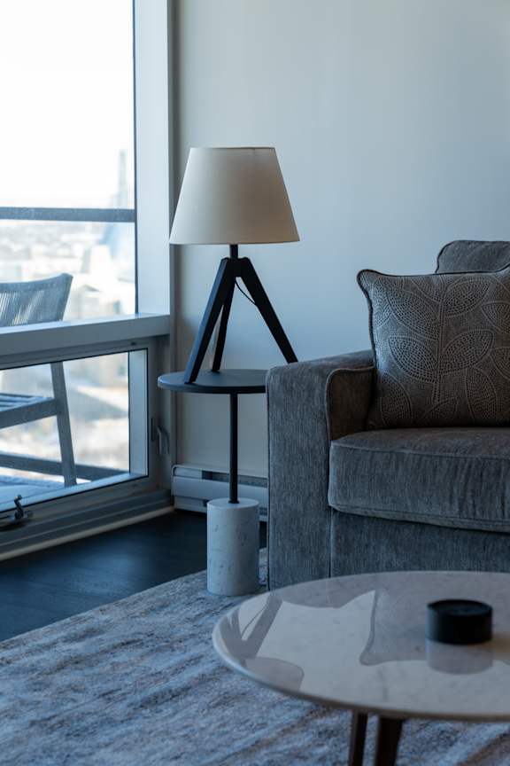 A table with a lamp and a cup on it.