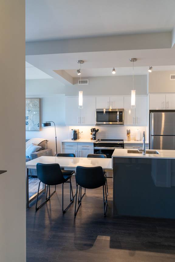 A modern kitchen with a dining table and chairs.