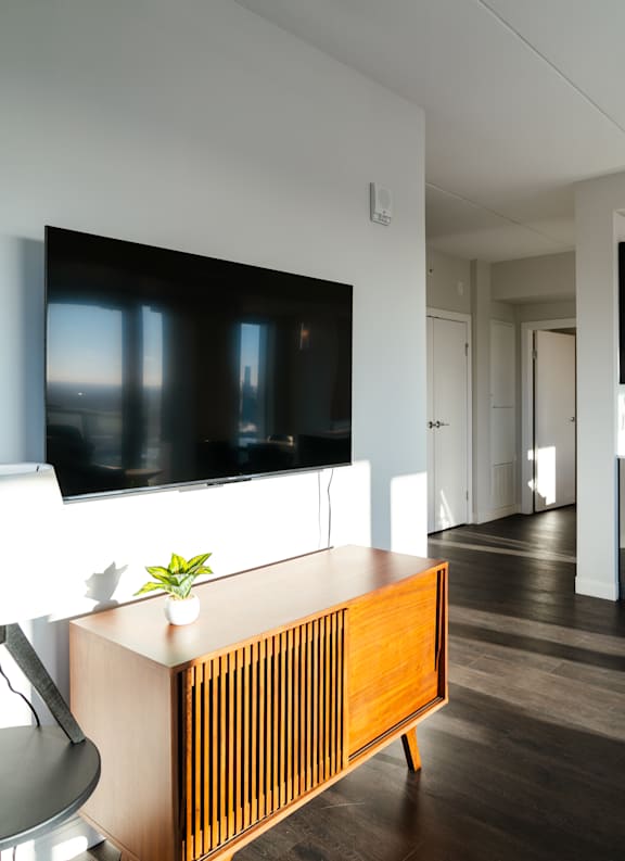 A modern living room with a flat screen TV mounted on the wall.