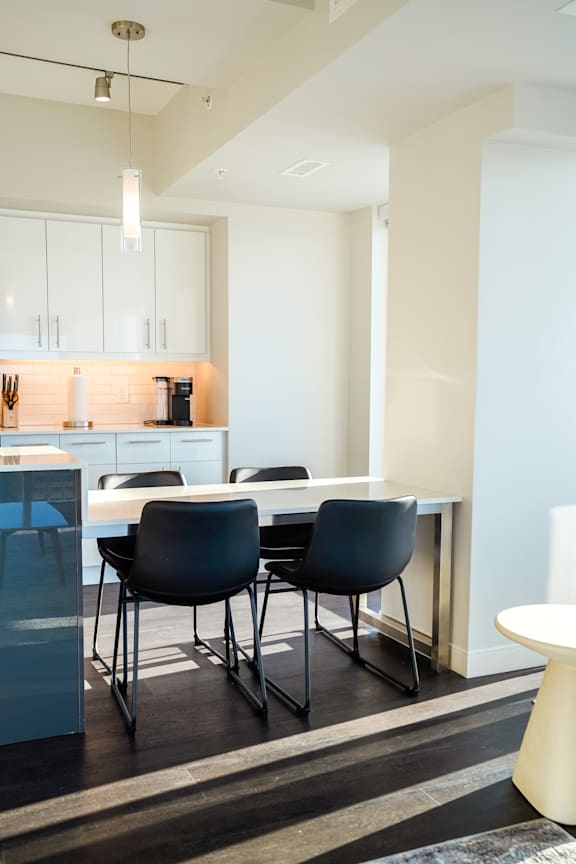 A modern kitchen with a dining table and chairs.