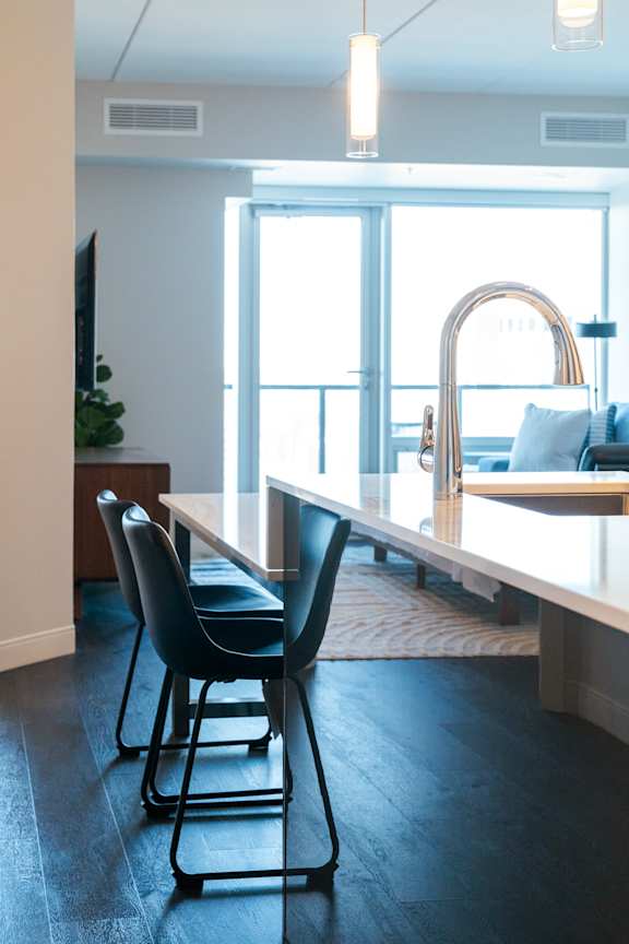 A modern dining room with a glass table and chairs.