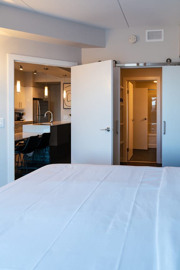 A white bed with a white sheet on it.
