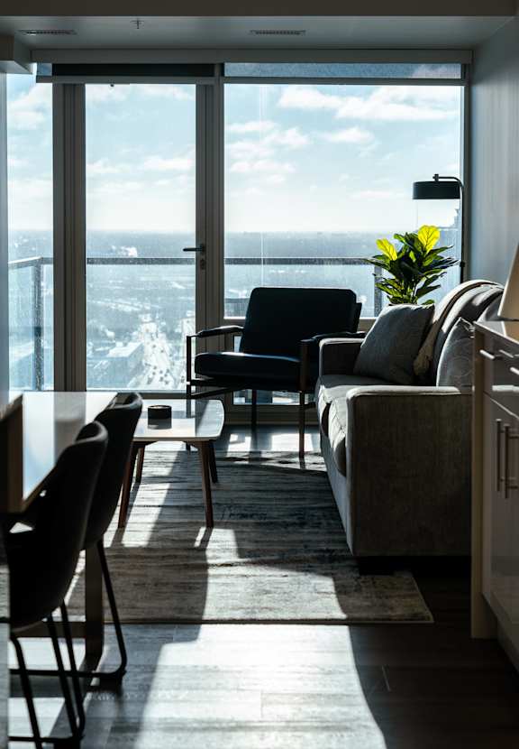 A living room with a view of the ocean through a large window.