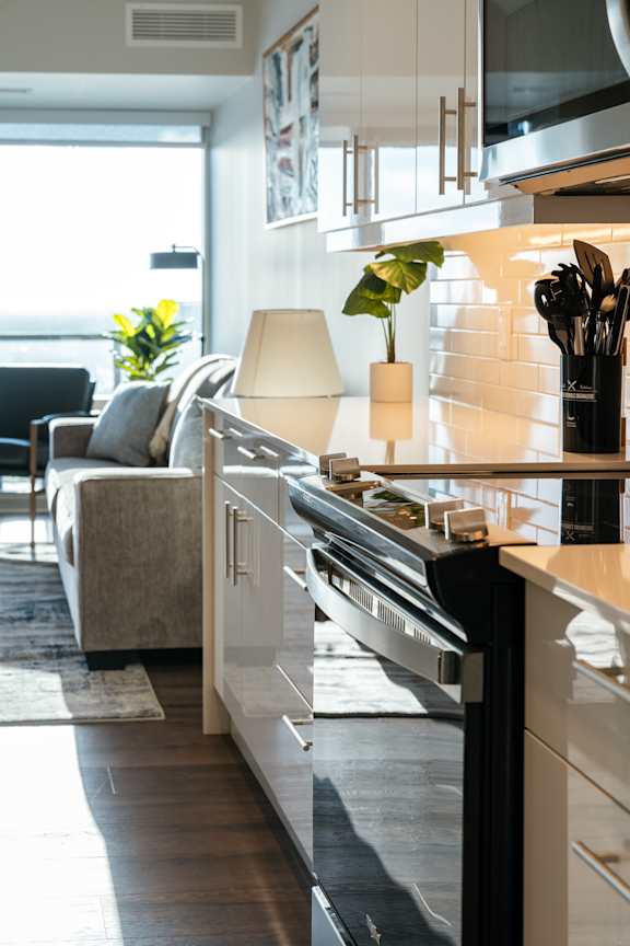 A modern kitchen with a large island and a dining area with a couch and chairs.