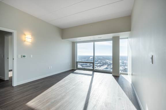 A room with a view of the city through a large window.