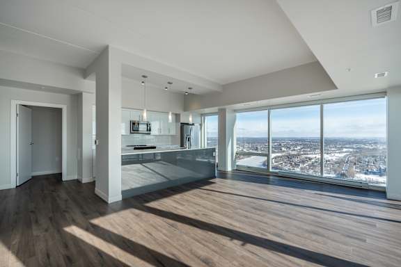 A large, empty room with a view of the cityscape outside the window.