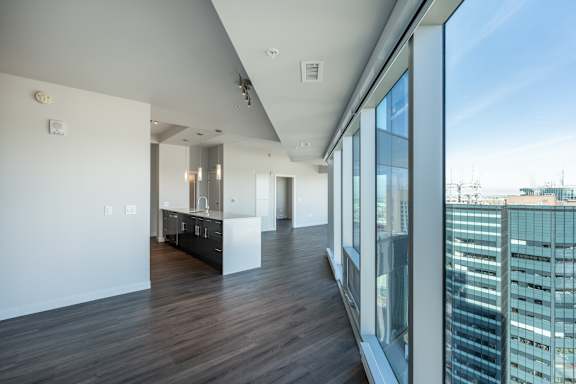 A long hallway with a view of the city outside the windows.