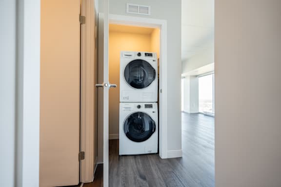 A white front loading washing machine in a laundry room.