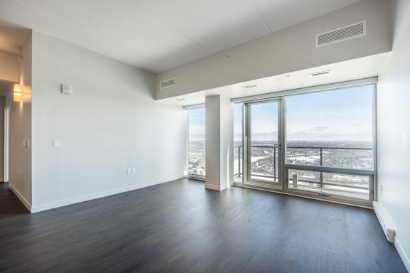 A large empty room with a view of the city.