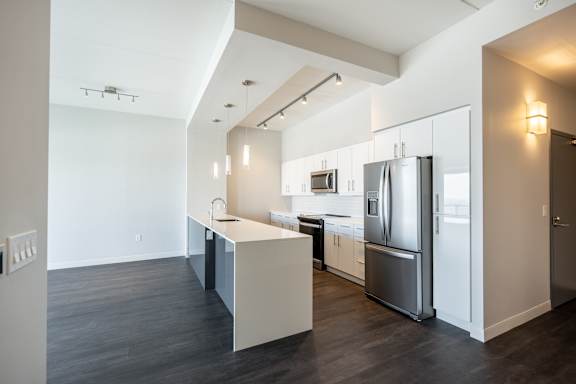 A modern kitchen with a refrigerator, sink, and cabinets.