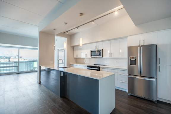 A modern kitchen with a large island and stainless steel appliances.