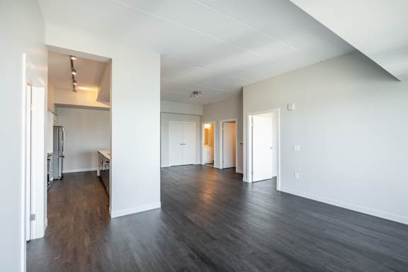 A spacious room with wooden floors and white walls.