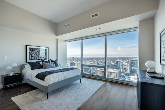 A bedroom with a large bed and a view of the city.