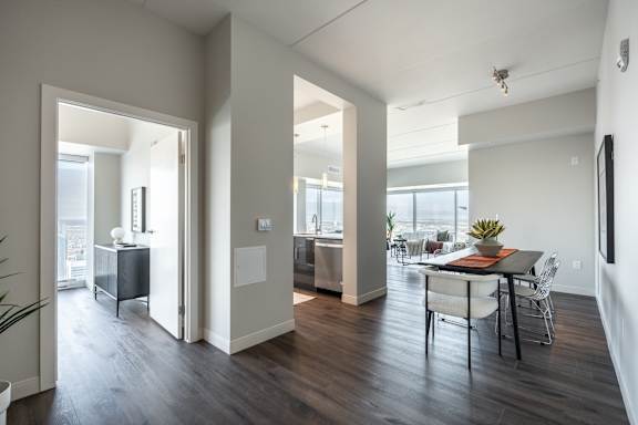 A modern open plan living and dining area with a kitchen in the background.