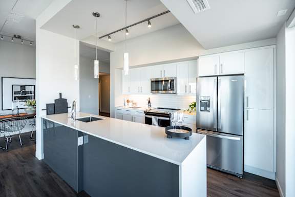 A modern kitchen with a white island and stainless steel appliances.