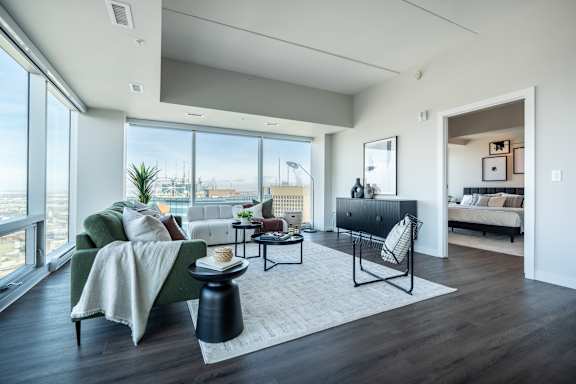A modern living room with a green couch and a view of the city.